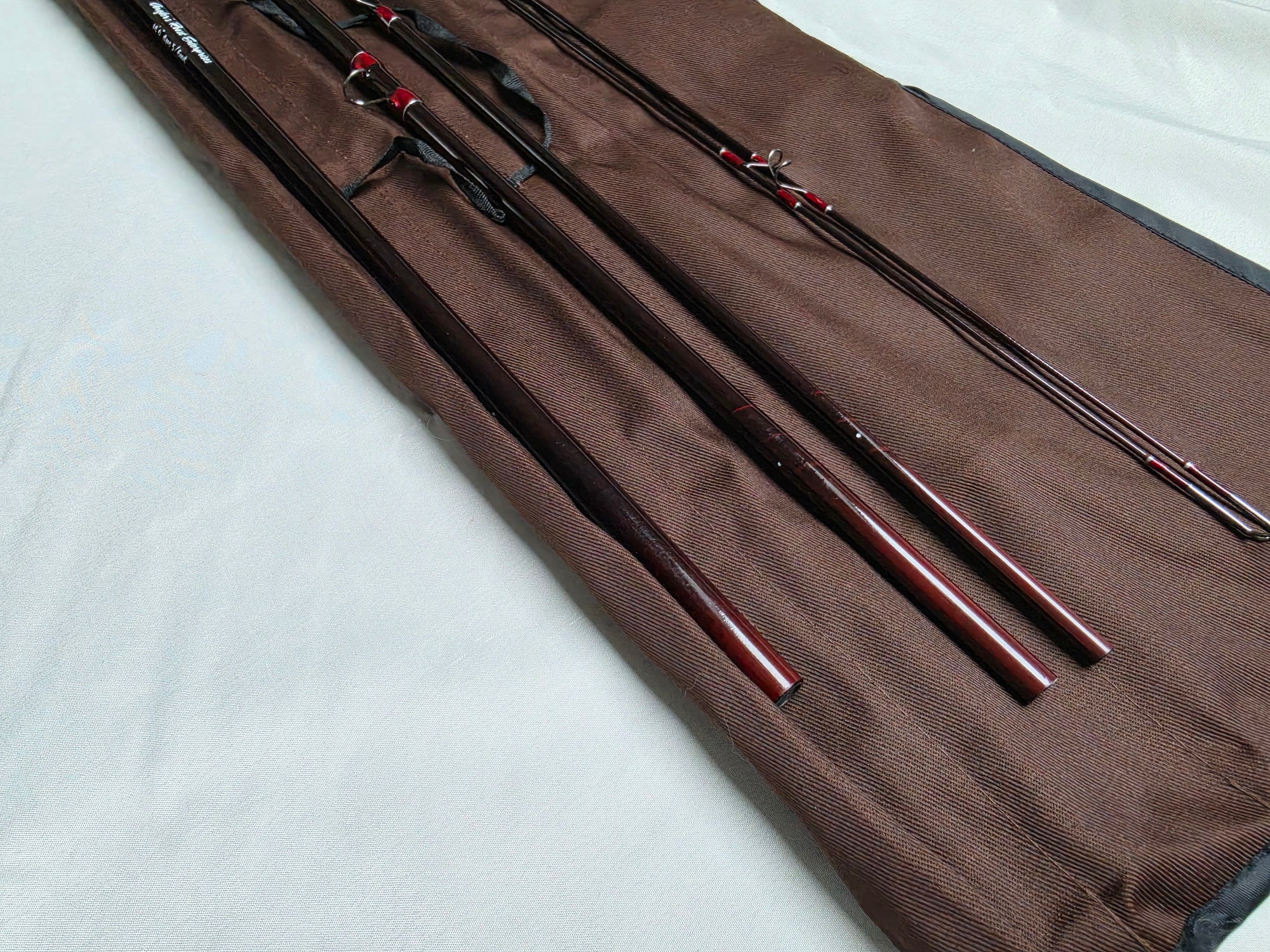 Four-piece IM6 graphite Spey rod sections in brown cloth rod bag